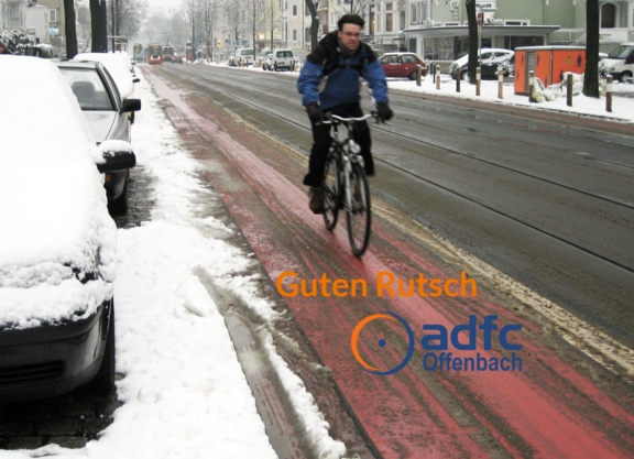 Ein Fahrradfahrer auf schneebedecktem Fahrradstreifen