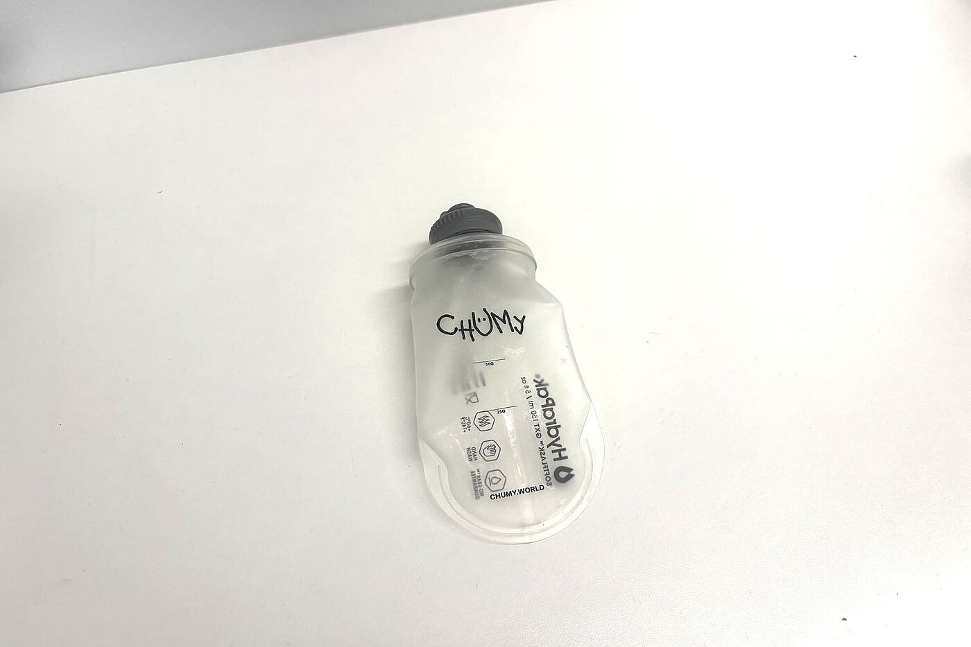 Ein Gelfläschchen mit Markierungen und Chumy-Schriftzug auf einem weißen Tisch. 